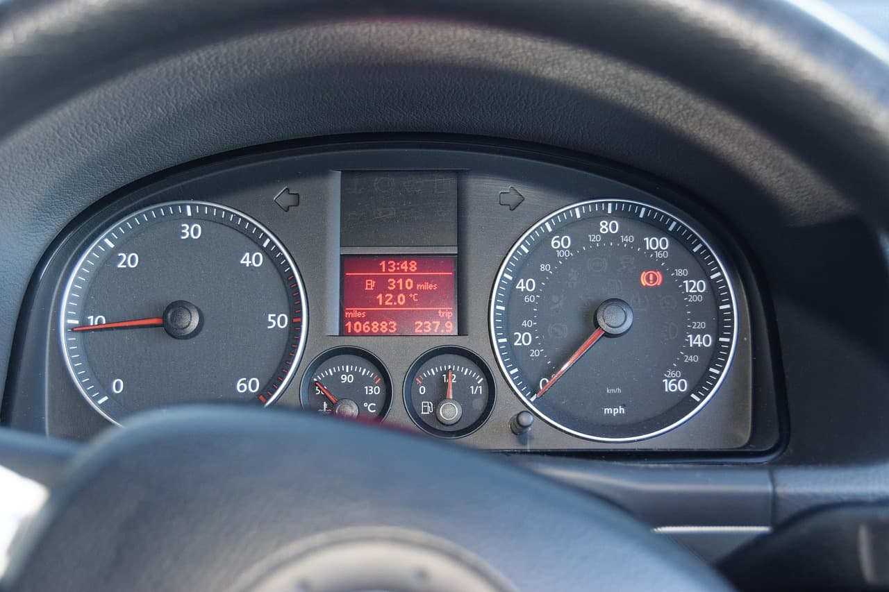 A car instrument cluster seen past the steering wheel