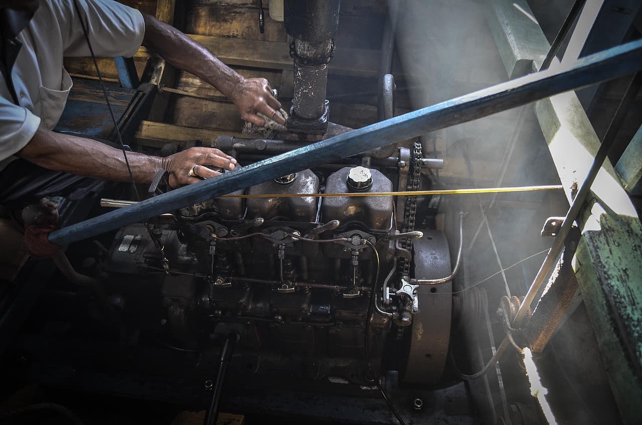Hands working on an engine in a workshop